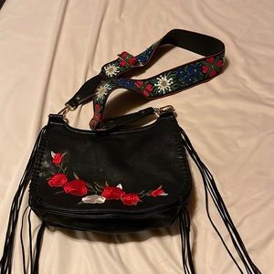 Black crossbody bag with tapestry design.